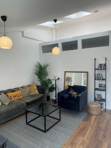 a living room with a couch and a table at 4Bed Loft Style Apartment With PrivateTerrace in London