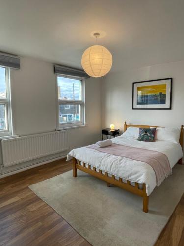 a bedroom with a large bed and a chandelier at 4Bed Loft Style Apartment With PrivateTerrace in London