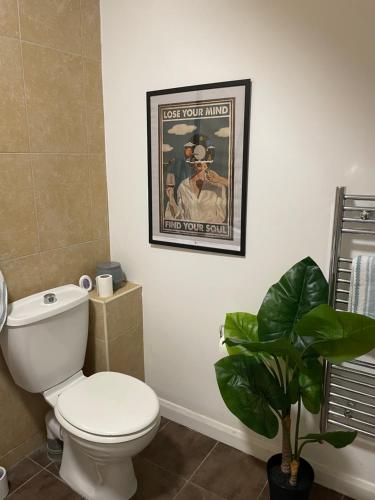 a bathroom with a toilet and a poster of a man at 4Bed Loft Style Apartment With PrivateTerrace in London
