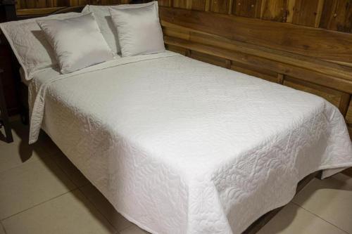 a large white bed with white sheets and pillows at Ayenda Marana in Manizales