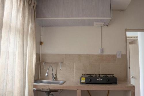a kitchen with a sink and a counter with a microwave at Ayenda Marana in Manizales