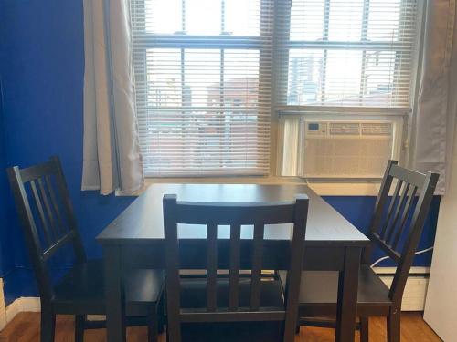 mesa de comedor con 2 sillas y ventana en Spacious & Cozy Studio, Short Walk to Yale en New Haven