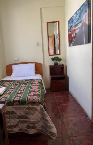 卡拉馬的住宿－Residencial Amanda Josefa，一间卧室配有一张床、一张桌子和一面镜子