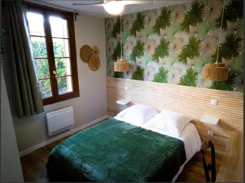 1 dormitorio con 1 cama con manta verde en Un coin paisible, en Camon