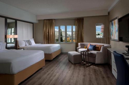 een hotelkamer met 2 bedden en een bank bij Courtyard Miami Beach South Beach in Miami Beach
