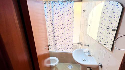 ein Badezimmer mit einem Waschbecken, einem WC und einem Spiegel in der Unterkunft Double window Partition Room in Tecom Near Metro in Dubai