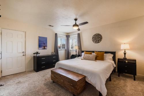 a bedroom with a large white bed with a wooden table at Nob Hill Home with Private Yard! in Albuquerque