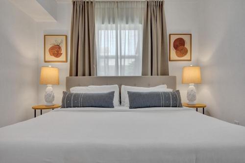 - une chambre avec un grand lit blanc et deux lampes dans l'établissement Marine Villas # 1, à Hollywood