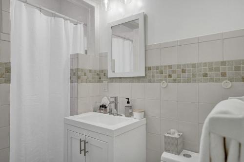 La salle de bains blanche est pourvue d'un lavabo et d'un miroir. dans l'établissement Marine Villas # 1, à Hollywood