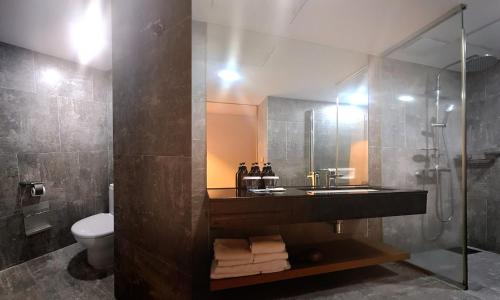 a bathroom with a sink and a shower and a toilet at Saint Beach Hotel in Jeju
