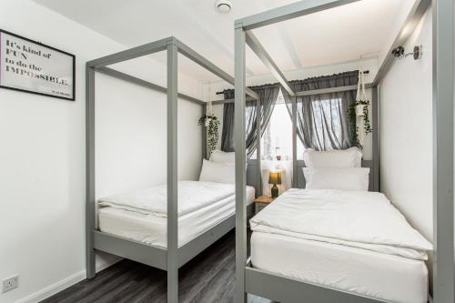 a bedroom with two bunk beds and a mirror at Unique Vintage Apartments in Goodmayes