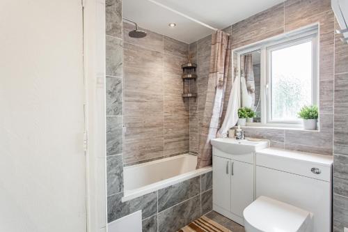 ein Badezimmer mit einer Badewanne, einem Waschbecken und einem WC in der Unterkunft Unique Vintage Apartments in Goodmayes