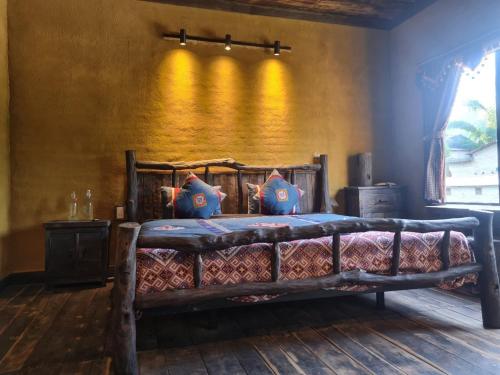 ein Holzbett mit Kissen in einem Zimmer in der Unterkunft Quan Din Ngai Villa in Dồng Văn
