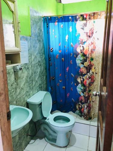 a bathroom with a fish shower curtain and a toilet at Zumag Sisa in Tena