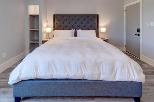 a bedroom with a large white bed with a blue headboard at Eagle’s Landing Lodge in Custer