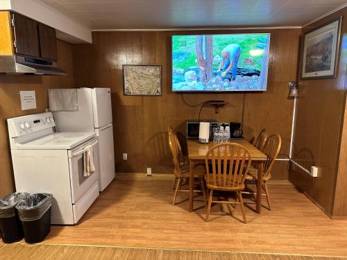 uma cozinha com uma mesa, um frigorífico e uma televisão em Angeles Motel em Port Angeles