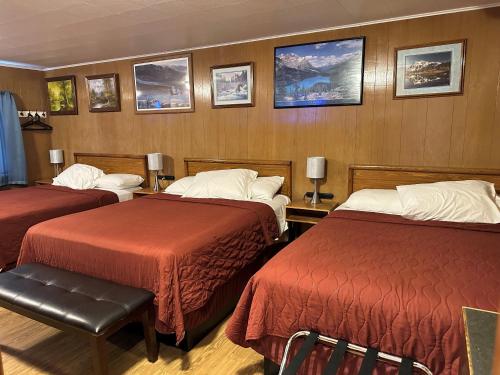 a hotel room with two beds and pictures on the wall at Angeles Motel in Port Angeles