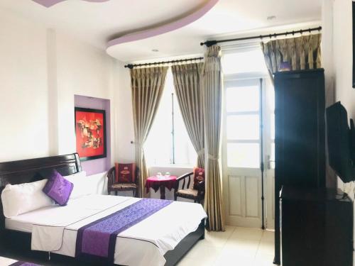 a bedroom with a bed and a window and a table at Hue thuong hotel in Hue