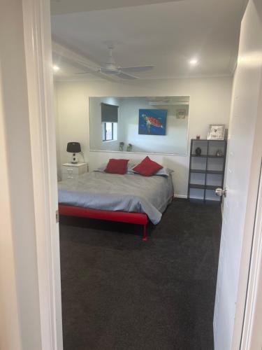 1 dormitorio con 1 cama con 2 almohadas rojas en River Heads K'Gari Fraser Island Adventure, en River Heads