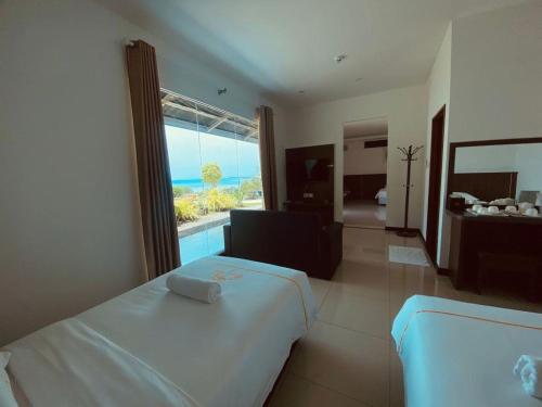 um quarto com uma cama e vista para o oceano em D View Holiday Homes em Kudat