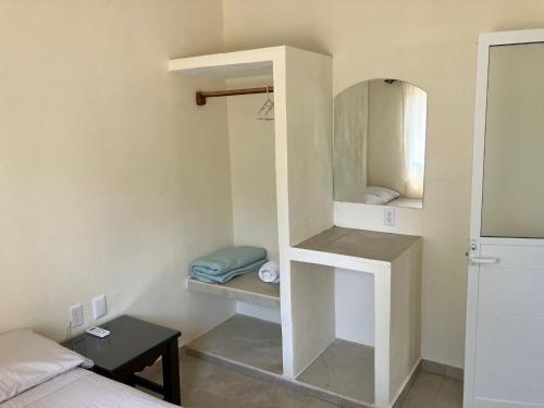 a small room with a bed and a mirror at Los Amores Apartments B in Pérula