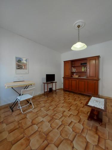 een kamer met een houten vloer, een tafel en een bureau bij Casa nel centro storico a Loreto, 2 km dal mare in Loreto