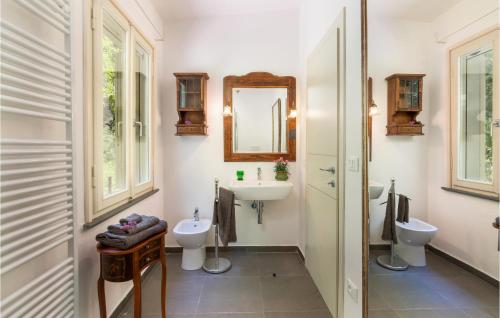 La salle de bains est pourvue de 2 toilettes, d'un lavabo et d'un miroir. dans l'établissement Casa Sul Serra, à Capannori