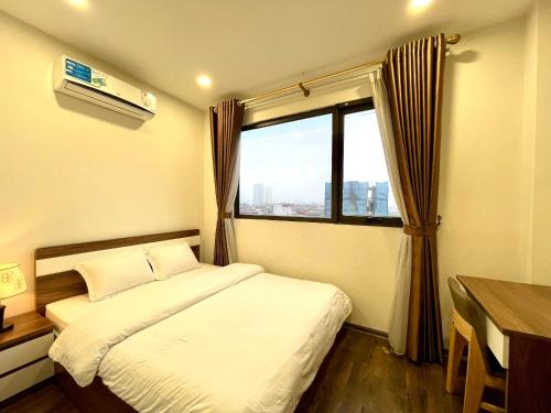 a small bedroom with a bed and a window at NINE HOUSING Buoi Street in Hanoi