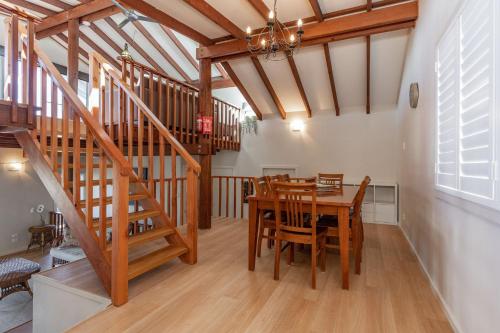a dining room with a table and a staircase at The Pole House in Elizabeth Beach