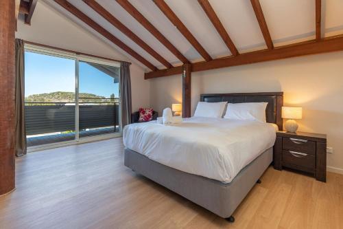 a bedroom with a large bed and a large window at The Pole House in Elizabeth Beach