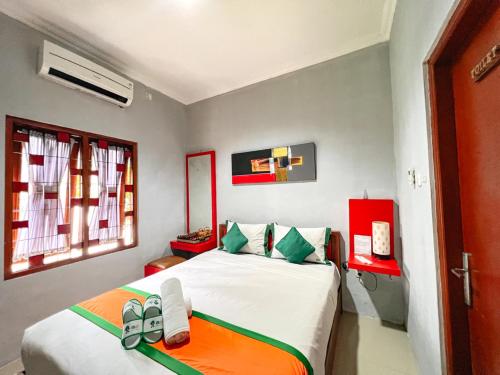 a bedroom with a bed with shoes on it at Homestay Simply Homy Jogja dekat Ambarukmo plaza in Yogyakarta