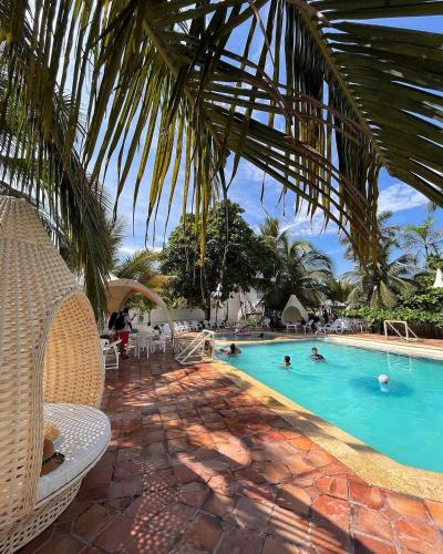 a swimming pool with people in the water at Hotel Tropical in isla de punta arena in Cartagena de Indias