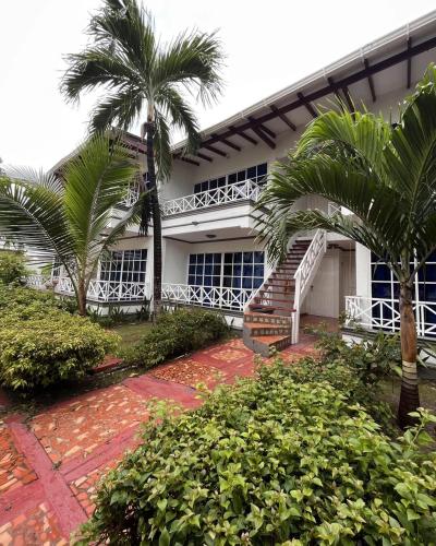 un bâtiment avec des palmiers en face de celui-ci dans l'établissement Hotel Tropical in isla de punta arena, à Carthagène des Indes