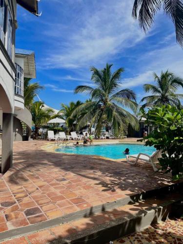 - une piscine entourée de palmiers dans l'établissement Hotel Tropical in isla de punta arena, à Carthagène des Indes
