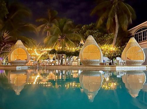 - une piscine dans un complexe la nuit dans l'établissement Hotel Tropical in isla de punta arena, à Carthagène des Indes