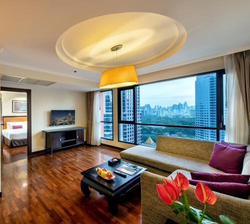 a living room with a couch and a table at Bandara Silom Suites, Bangkok in Bangkok