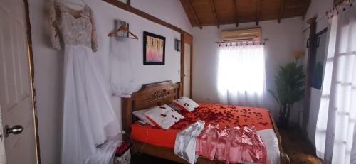 a bedroom with a bed with red sheets and a window at Los Flamingos Vip in Santa Rosa