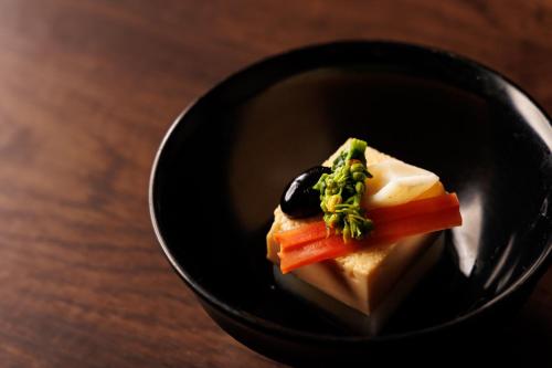 a black bowl with food in it on a table at Fukeikan 風景館 in Takayama