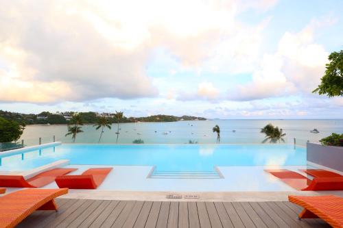a swimming pool with a view of the ocean at Bandara Beach Resort, Phuket in Panwa Beach