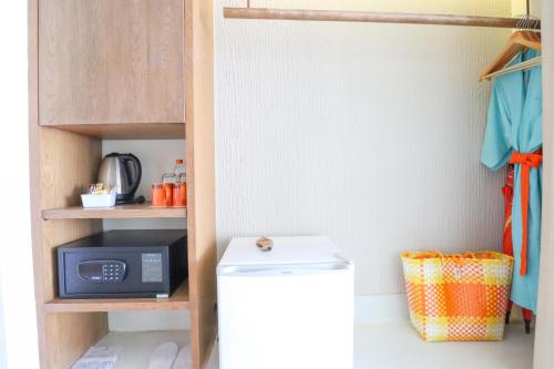 a kitchen with a small refrigerator and a microwave at Bandara Beach Resort, Phuket in Panwa Beach
