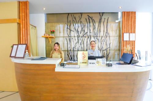 two people sitting at a counter in a store at Bandara Beach Resort, Phuket in Panwa Beach