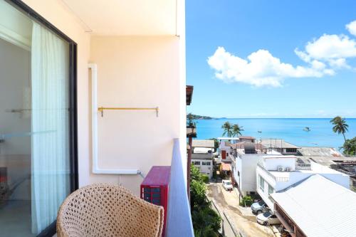 a balcony with a chair and a view of the ocean at Bandara Beach Resort, Phuket in Panwa Beach