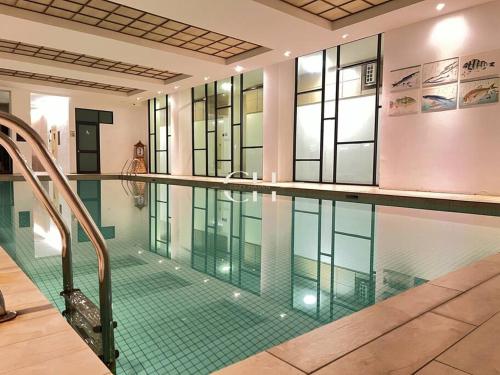 a large swimming pool in a building with a pool at Zen 66 near to Boulevard & Aeon Kuching in Kuching