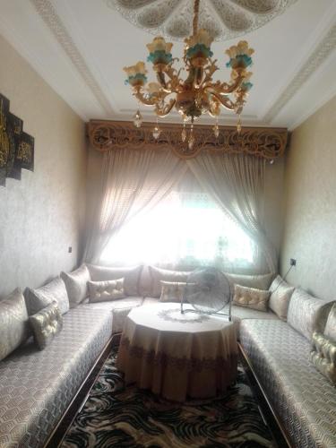 - un salon avec un canapé et une table en face d'une fenêtre dans l'établissement Meknès kamilia, à Meknès