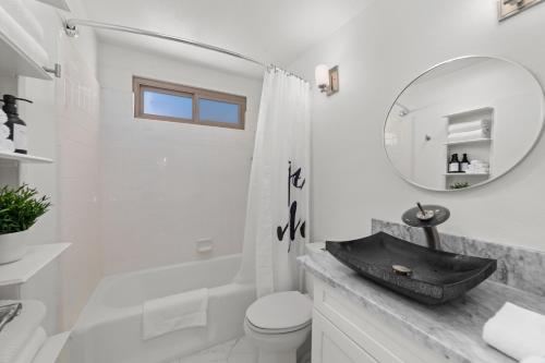 ein Badezimmer mit einem Waschbecken, einem WC und einem Spiegel in der Unterkunft Cali-Craftsman - 3BR - New Backyard - Central - AC in San Diego