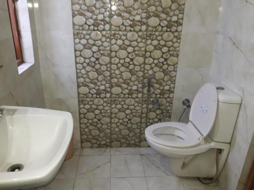 a bathroom with a toilet and a sink and a shower at StayApart I The Maple Residences - Lake Front in Nainital