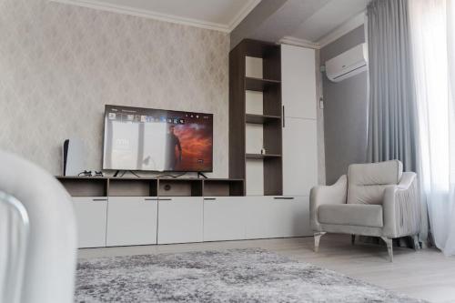 un salon avec une télévision et une chaise dans l'établissement RentWill apartments Diplomat, à Chişinău