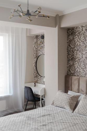 a bedroom with a bed and a desk with a mirror at RentWill apartments Diplomat in Chişinău