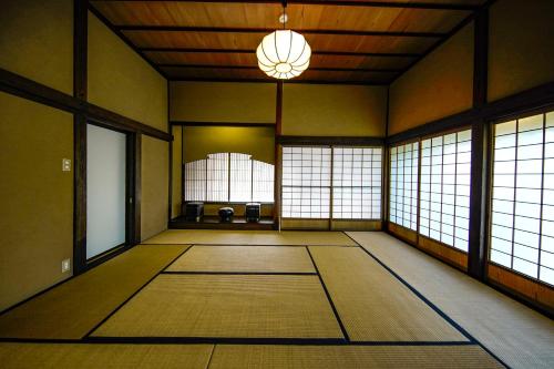 an empty room with windows and a chandelier at 甘糟屋敷 Amakasu Yashiki KAMAKURA in Kamakura