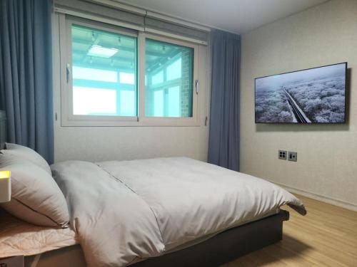 a bedroom with a large bed and a window at Sunshine Aewol Entire House in Jeju
